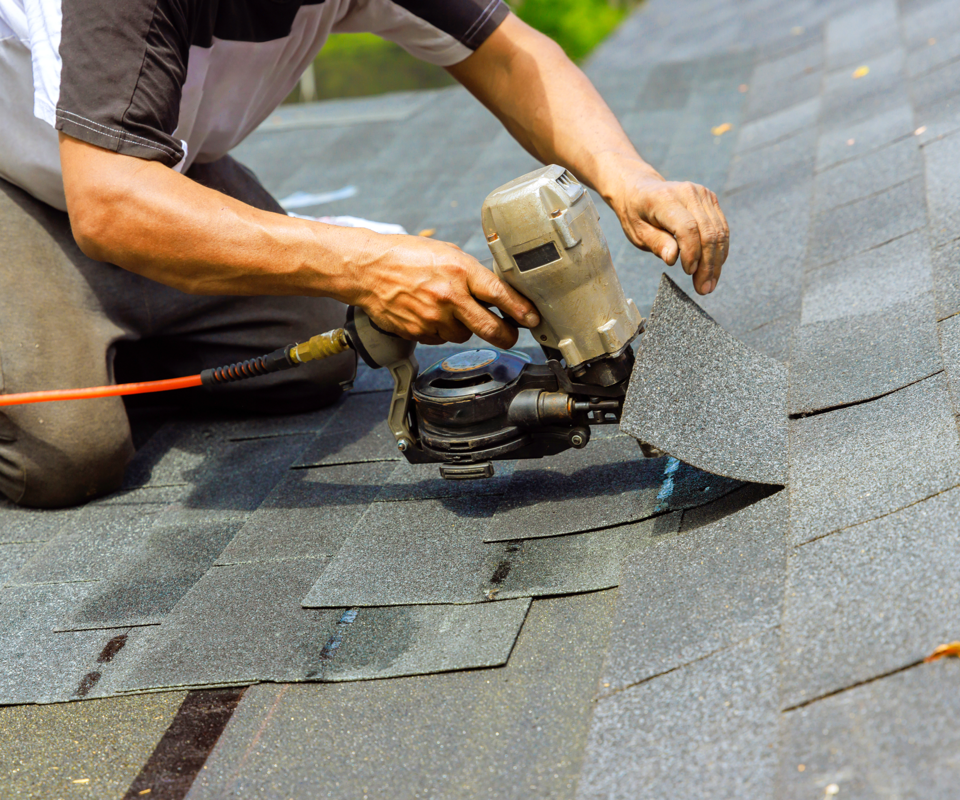 Worker repairing residential roof shingles